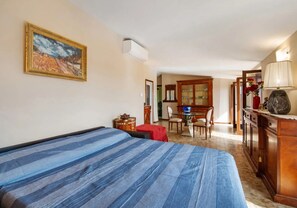 Ein Schlafzimmer mit einem Bett, einem Schreibtisch, einem Stuhl und einem Esstisch mit Stühlen.