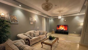 Una sala de estar con un sofá color beige, una mesa de centro y una chimenea.