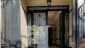 Una entrada imponente con una reja metálica y una planta en maceta.