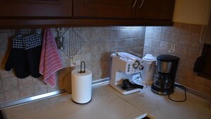 Une cuisine équipée d’un grille-pain, d’une machine à café et d’un rouleau d’essuie-tout posé sur le comptoir.