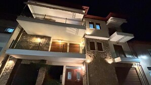 Une maison à deux étages avec un balcon, un garage et une entrée bien éclairée.