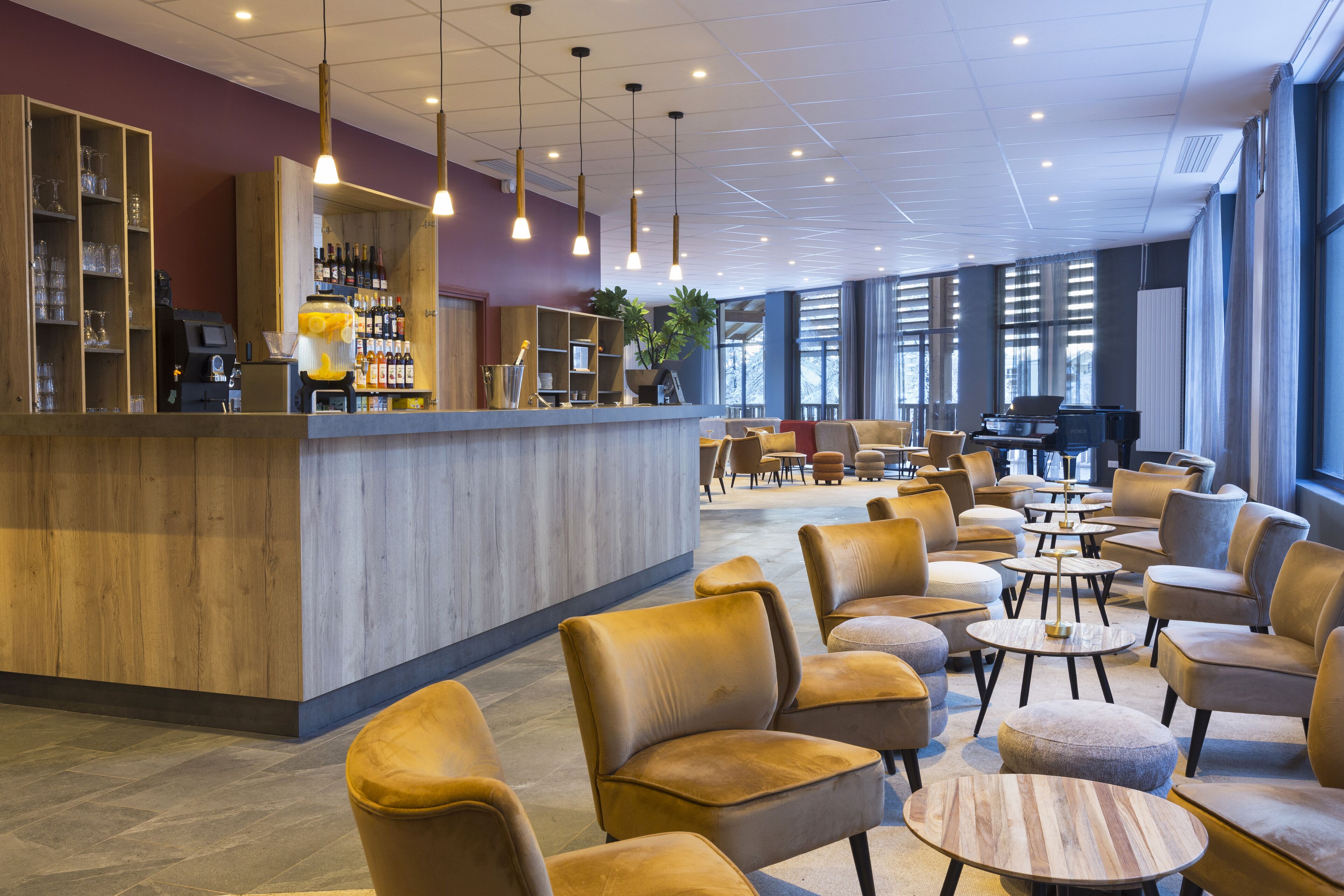 A modern hotel lobby with a bar area, seating arrangements, and large windows.