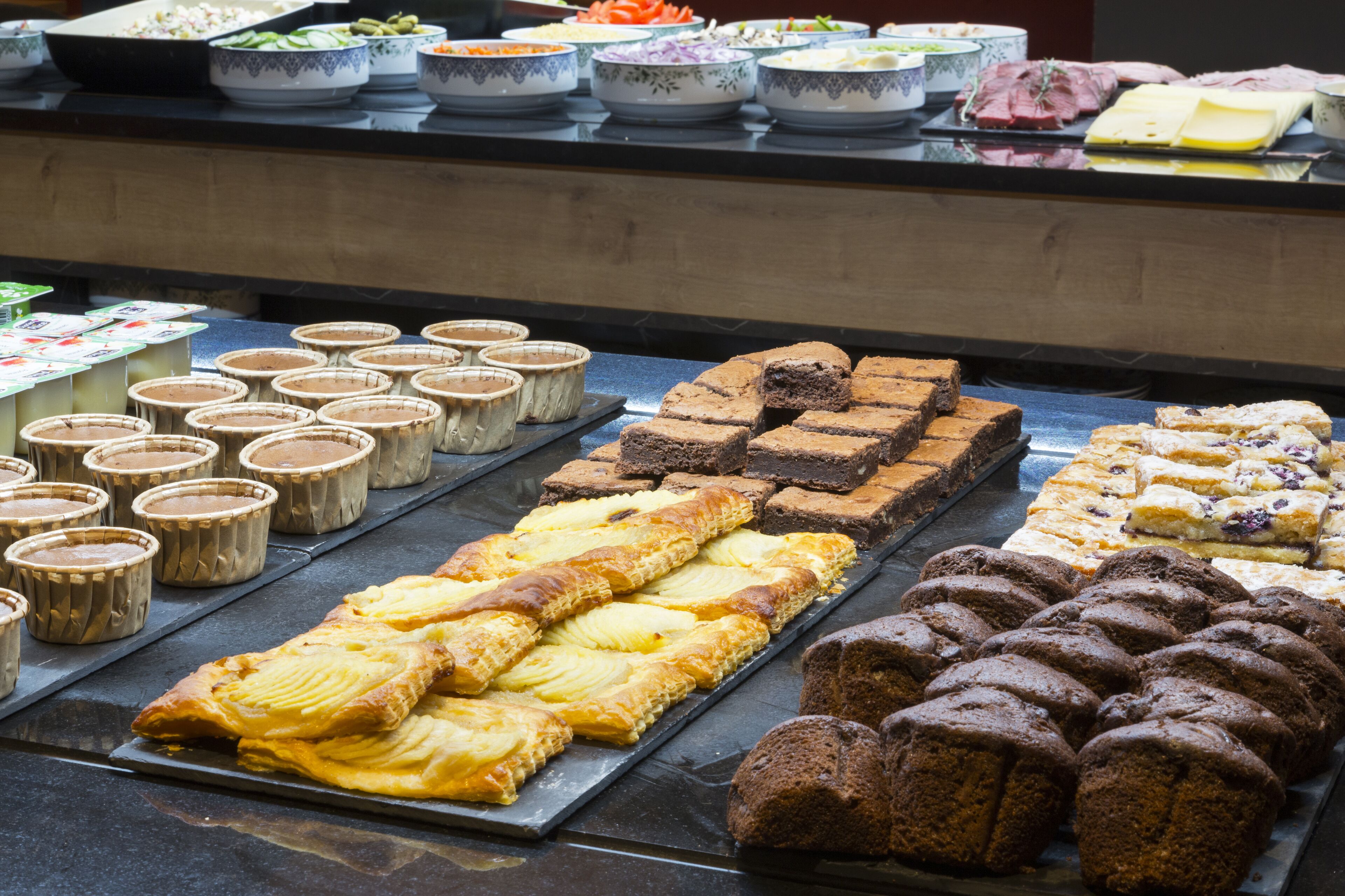 A buffet with various baked goods and desserts.
