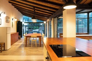 A spacious kitchen with a wooden countertop, a built-in stove, and a dining area with a table and chairs.
