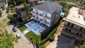 Ein mehrstöckiges Hotel mit Pool auf dem Dach und Außenbereich zum Sitzen.