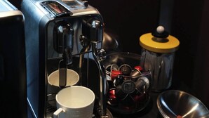 A coffee machine with a cup and a container of coffee pods. - Pudong airport W9 hotel Shanghai (Shanghai)