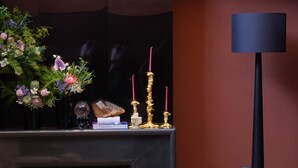A modern living room with a fireplace, a black leather chair, a round coffee table, and a decorative vase with flowers. - Pudong airport W9 hotel Shanghai (Shanghai)