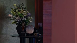 A room with a round table, a vase with flowers, and a textured wall. - Pudong airport W9 hotel Shanghai (Shanghai)