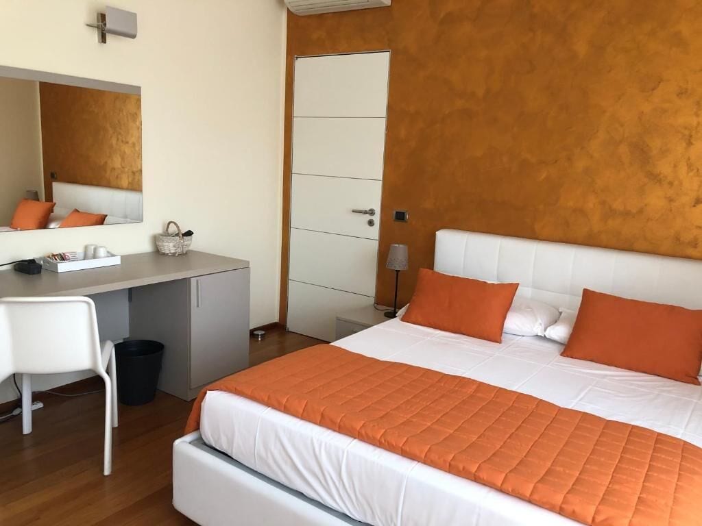 Un dormitorio con cama, escritorio, silla y armario.