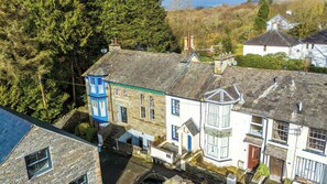 A traditional stone building with a bay window, a small porch, and a chimney. - Candy Cottage | 3-Bed, Walk to Lake & Village (Windermere)