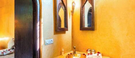 A bathroom with a sink, mirror, and decorative elements.
