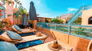 Terrassa al terrat amb gandules, una piscina i vista d'un edifici amb una escala.