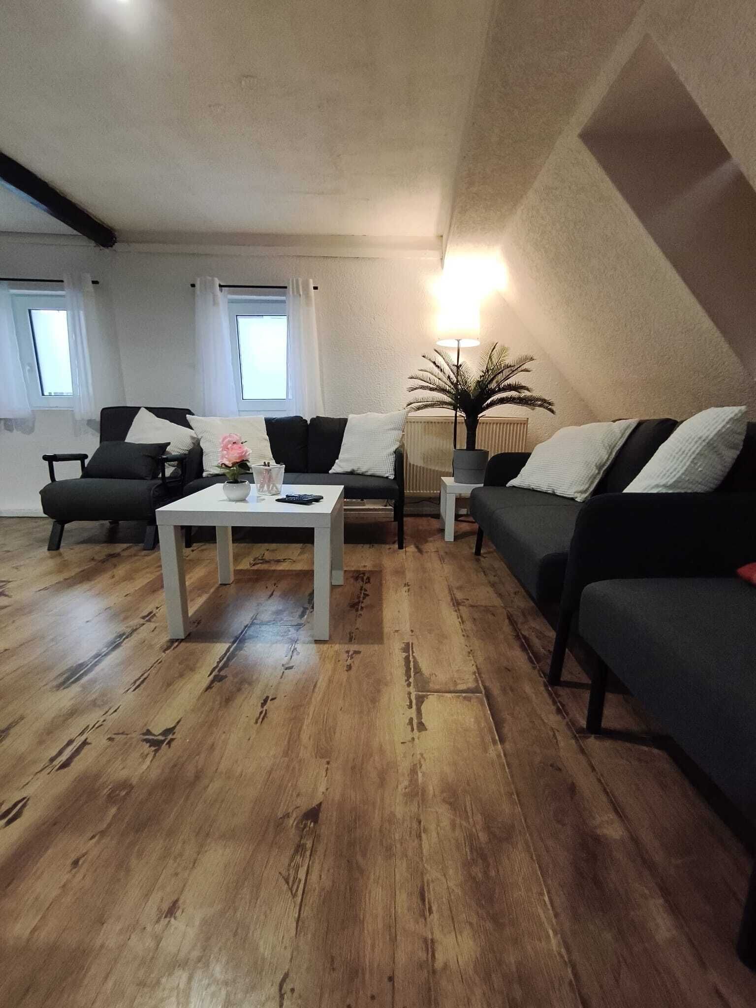 Un salon moderne avec une table basse blanche, deux canapés et un lampadaire.
