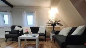 Een moderne woonkamer met een witte salontafel, twee banken en een vloerlamp.