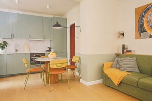 A compact living space with a dining area, a sofa, and a kitchen. - CS Trastevere Glorioso Signature Apt. (Rome)