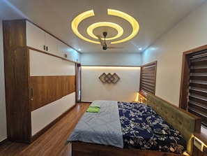 Un dormitorio con cama, armario de madera y lámpara en el techo.
