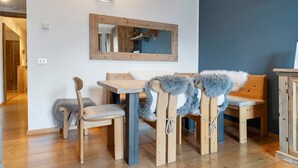 A dining area with wooden furniture, a mirror, and a blue accent wall. - Apartment 'Relax At The Mountain' with Mountain View, Shared Terrace and Wi-Fi (Madonna di Campiglio)