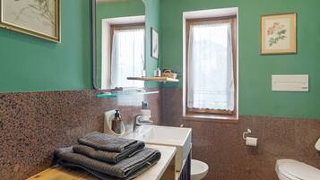 Un baño con lavabo, espejo, inodoro y ventana.
