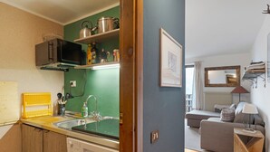A compact kitchen with a dishwasher, microwave, and green backsplash. - Apartment 'Relax At The Mountain' with Mountain View, Shared Terrace and Wi-Fi (Madonna di Campiglio)
