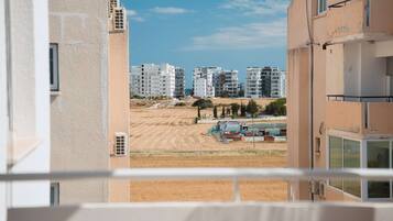 Una veduta di una zona residenziale con diversi condomini, una distesa sabbiosa e alcuni materiali edili in vista.