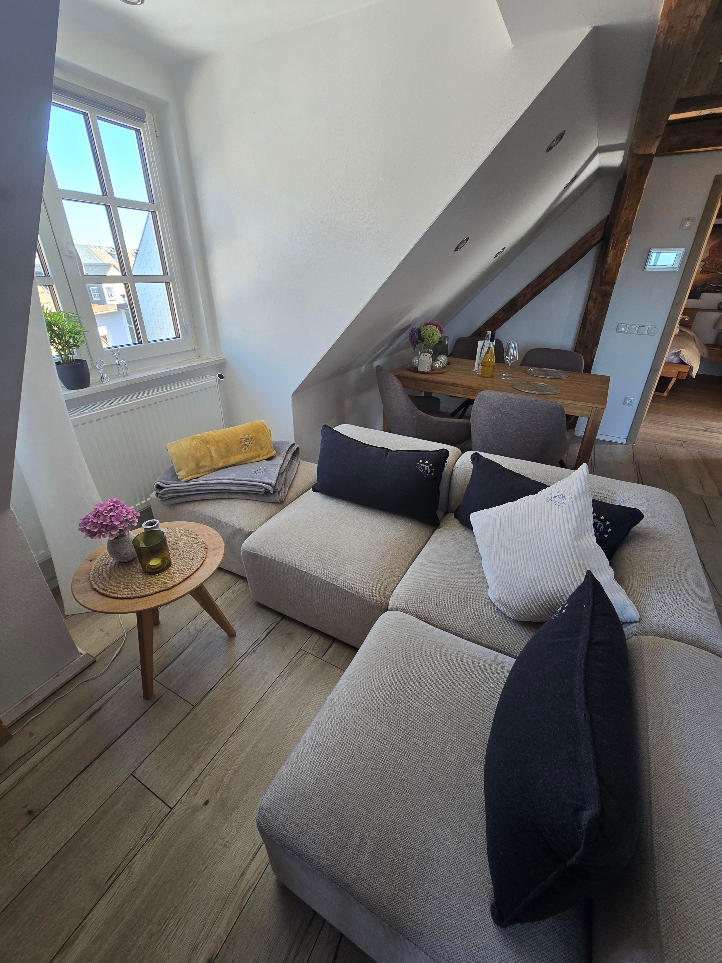 Ein gemütlicher Wohnbereich mit einer Couch, einem kleinen runden Tisch und einem Fenster mit Blick.