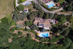An aerial view of a residential area with solar panels, a swimming pool, and a red car parked near the house. - Bed and Breakfast 'Les Issignols' with Mountain View, Wi-Fi and Air Conditioning (Colombier-le-Vieux)