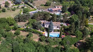 Vue aérienne d’un quartier résidentiel avec des maisons, une piscine et de la végétation environnante.