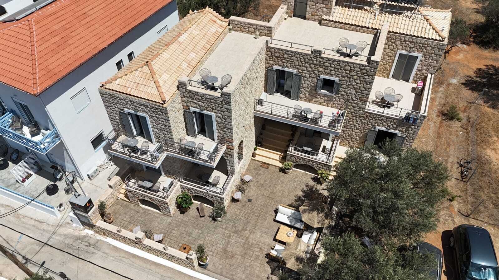 Un edificio de piedra de dos pisos con asientos exteriores y un patio.