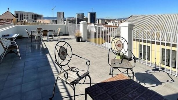 A rooftop terrace with outdoor seating, including metal chairs and a table, under a clear blue sky. - Stylish 1BR City Apartment with Stunning Rooftop Terrace (Gibraltar)