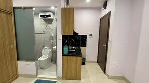 Ein modernes Badezimmer mit einer Duschkabine, einer Toilette und einem Waschbecken mit Arbeitsplatte.