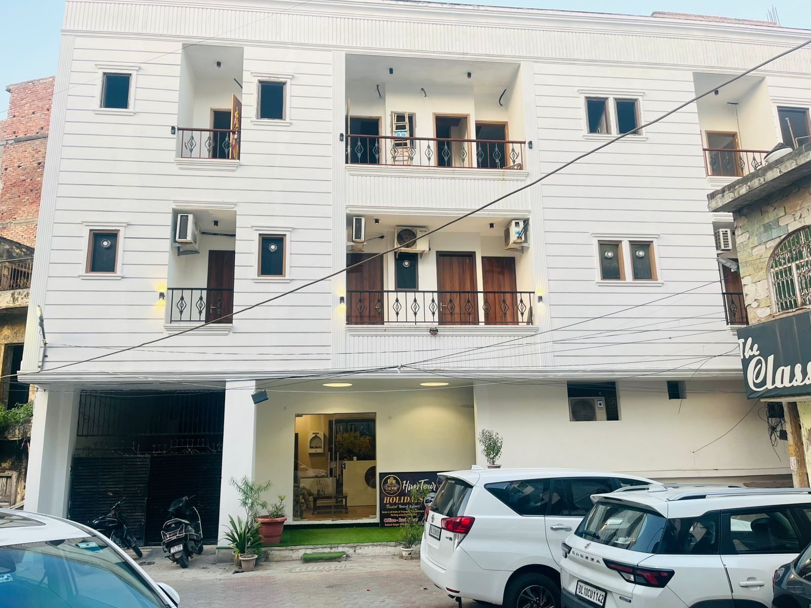 A multi-story building with balconies, air conditioning units, and a visible entrance.