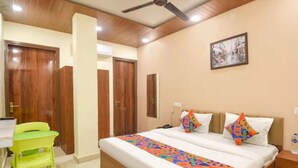 Une chambre à coucher avec un lit, un bureau, une chaise et un ventilateur de plafond.