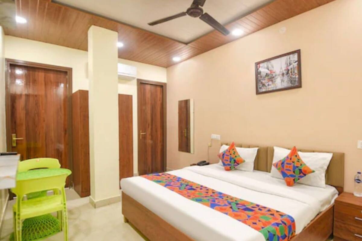 A bedroom with a bed, a desk, a chair, and a ceiling fan.
