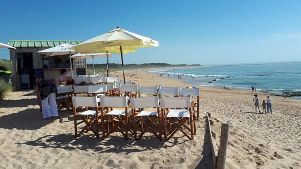 Un restaurante frente a la playa con terraza y vistas al océano.