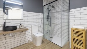 A modern bathroom with a glass shower enclosure, a white toilet, a sink with a black basin, and a wooden vanity. - Travel Habitat Nou Mestalla 4 (Valencia)