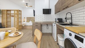 A modern kitchen with a wooden countertop, white tiled backsplash, and a built-in dishwasher. - Travel Habitat Nou Mestalla 4 (Valencia)