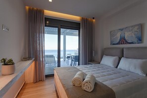 Ein modernes Hotelzimmer mit einem großen Bett, Meerblick und einem Balkon.