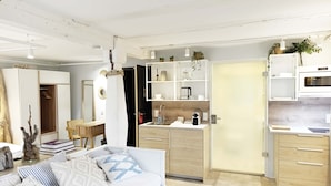 A modern kitchen with white cabinets, a microwave, and a sink.