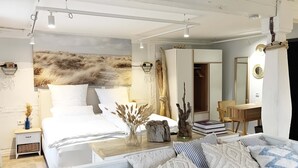 A modern bedroom with a large bed, bedside tables, a wooden dresser, and a mirror.