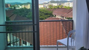 A balcony with a view of buildings and mountains. - Charming Condo in Wichit Comfort Meets Convenience (Wichit)
