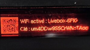Una pantalla digital con un código QR e información sobre WiFi.