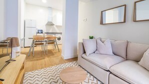 Ein modernes Wohnzimmer mit einer Couch, einem Couchtisch und einem Essbereich mit Stühlen und einem Tisch.