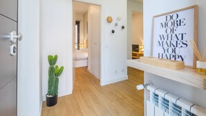 Ein modernes Interieur mit Holzboden, einer Kakteenpflanze, einem motivierenden Zitat an der Wand und einer Heizung.