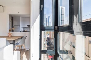 Une cuisine moderne avec un coin repas, de grandes fenêtres et une vue sur le paysage urbain.
