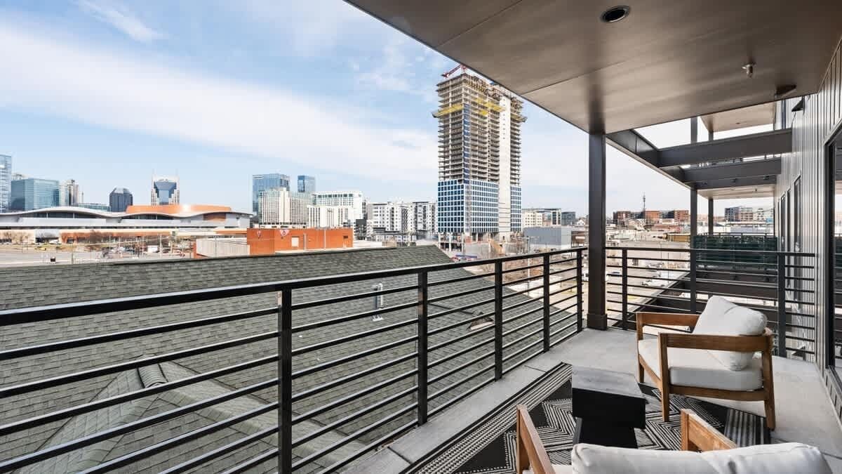 Un balcón con vistas a un paisaje urbano, que incluye un edificio alto en construcción.