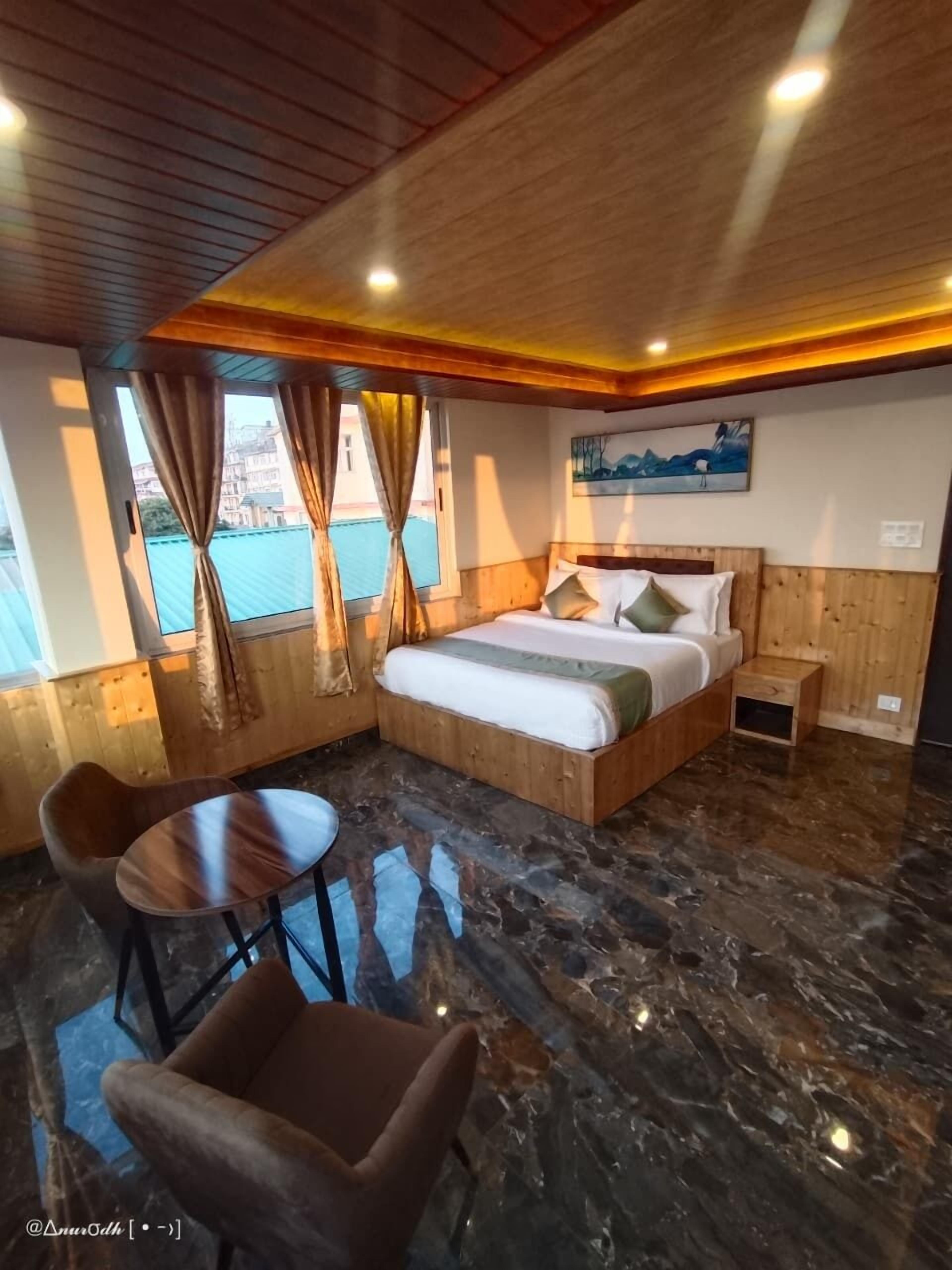 A bedroom with a bed, a small table, and a chair.