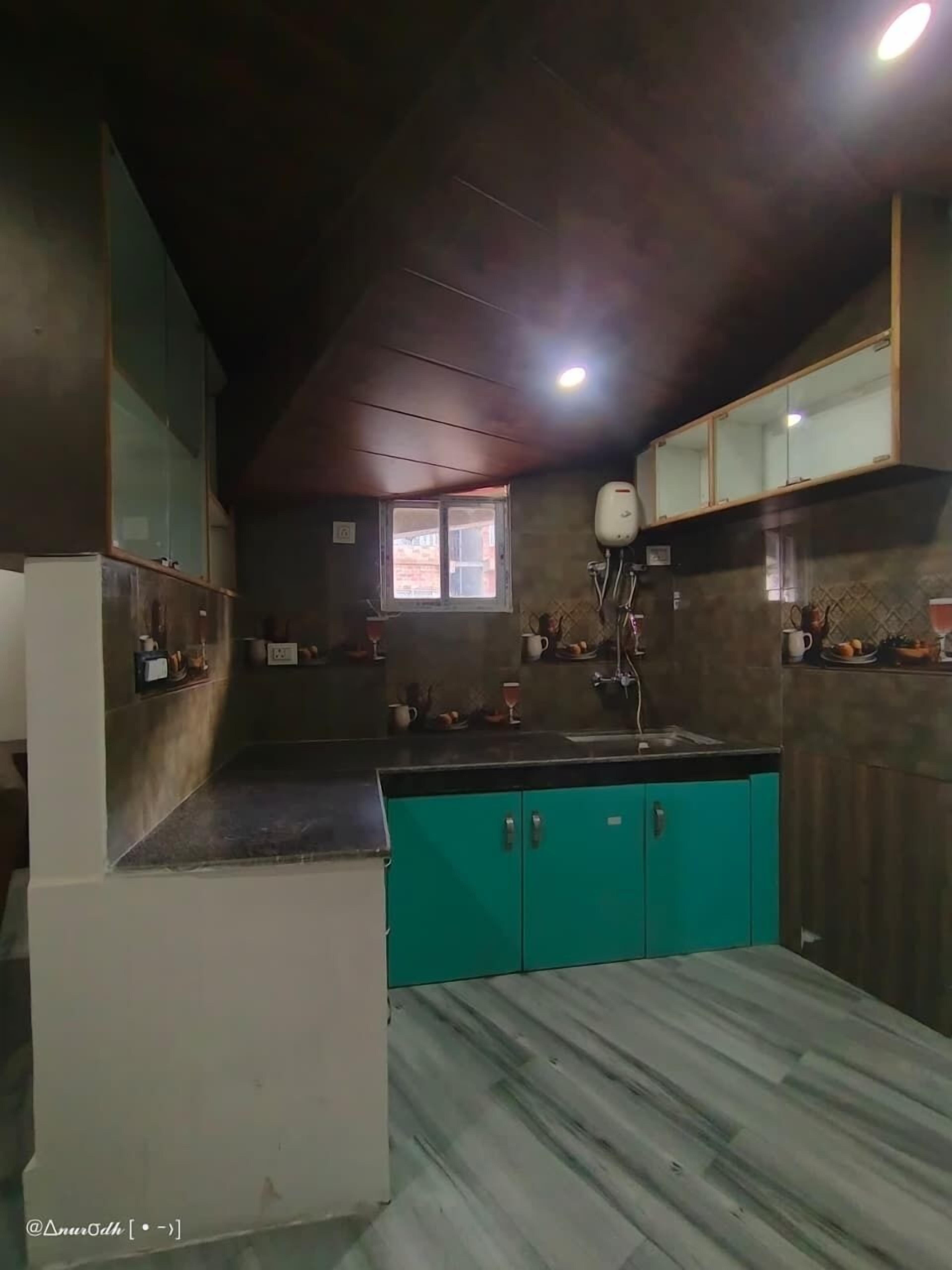 A kitchen with teal cabinets, a window, and a sink.