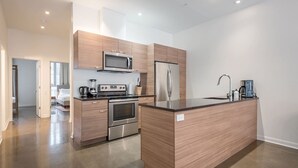 Eine moderne Küche mit Edelstahlgeräten, Holzschränken und einer zentralen Kochinsel.