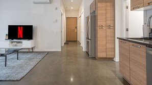 Une cuisine moderne avec des meubles en bois, un réfrigérateur en acier inoxydable et un lave-vaisselle encastré.