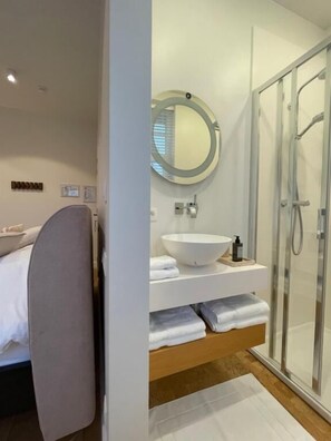 Deluxe tweepersoonskamer | Badkamer | Een douche, een haardroger, handdoeken